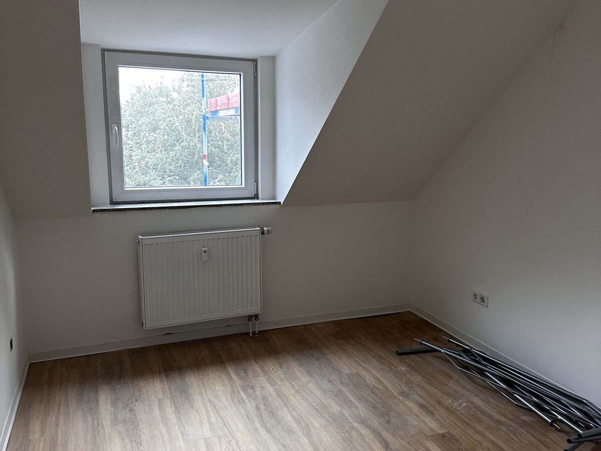 Dieselbe Wohnung nach der Kernsanierung — heller, bezugsfertiger Raum mit neuem Boden und Heizung